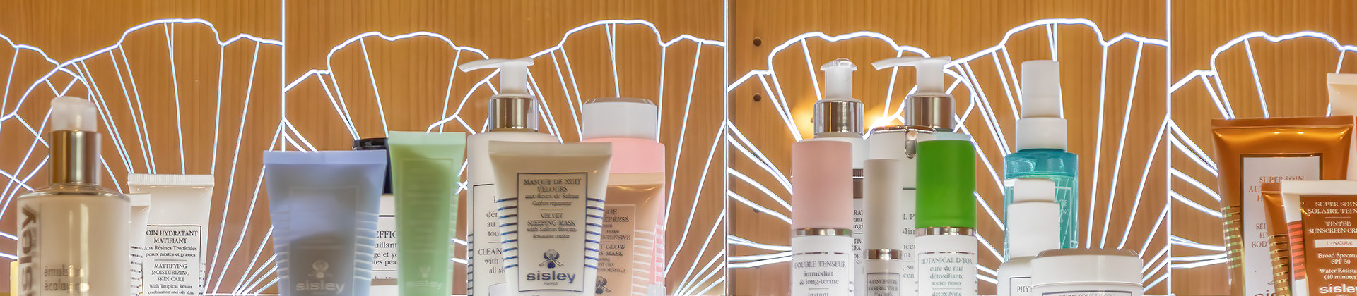 a variety of lotions and creams on display with lighting from below