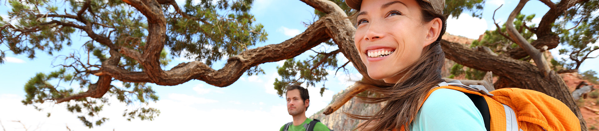 a woman and man smiling and hiking during the day