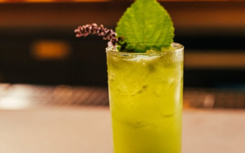 yellow drink with green garnish