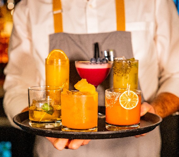 tray of drinks being carried by bar tender