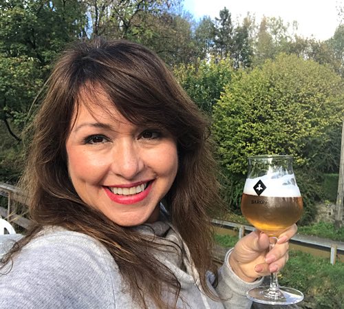 woman holding beer glass and smiling at the camera-1