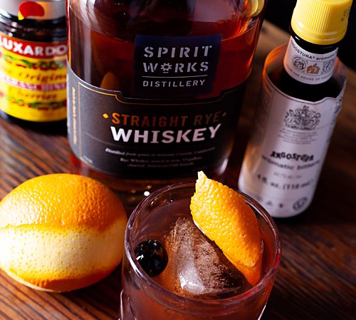 Spirit works whiskey next to low ball with orange in it-1