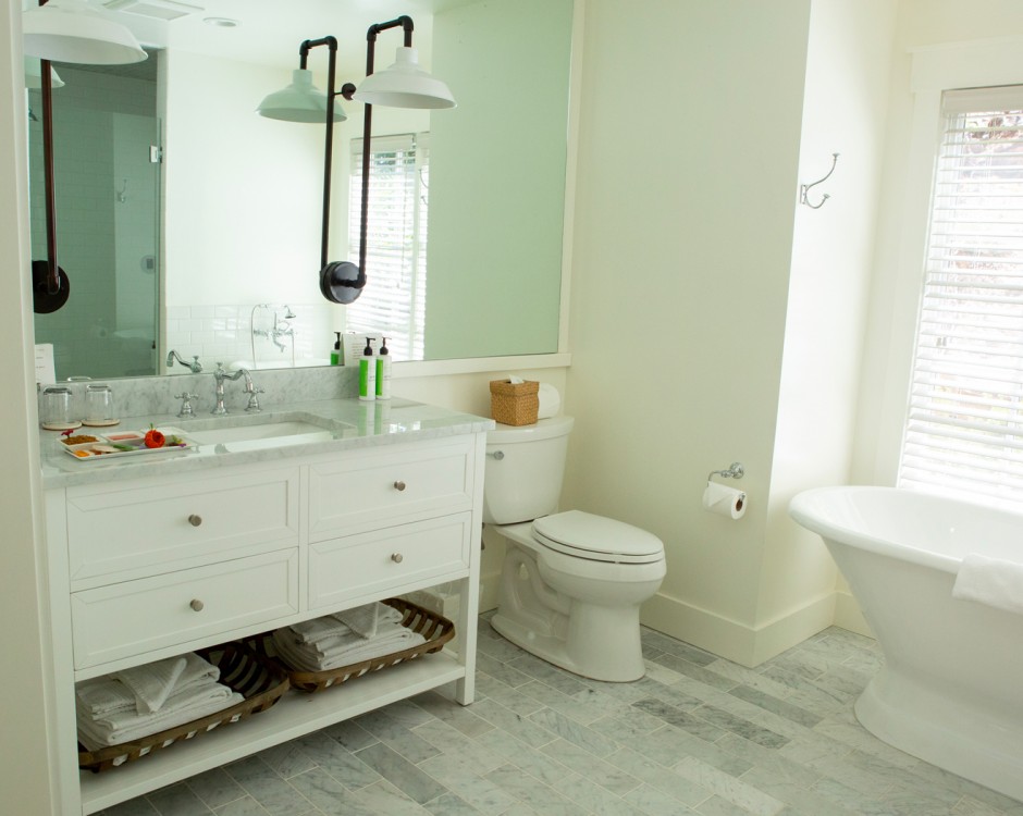 bathroom with white tub and large mirror