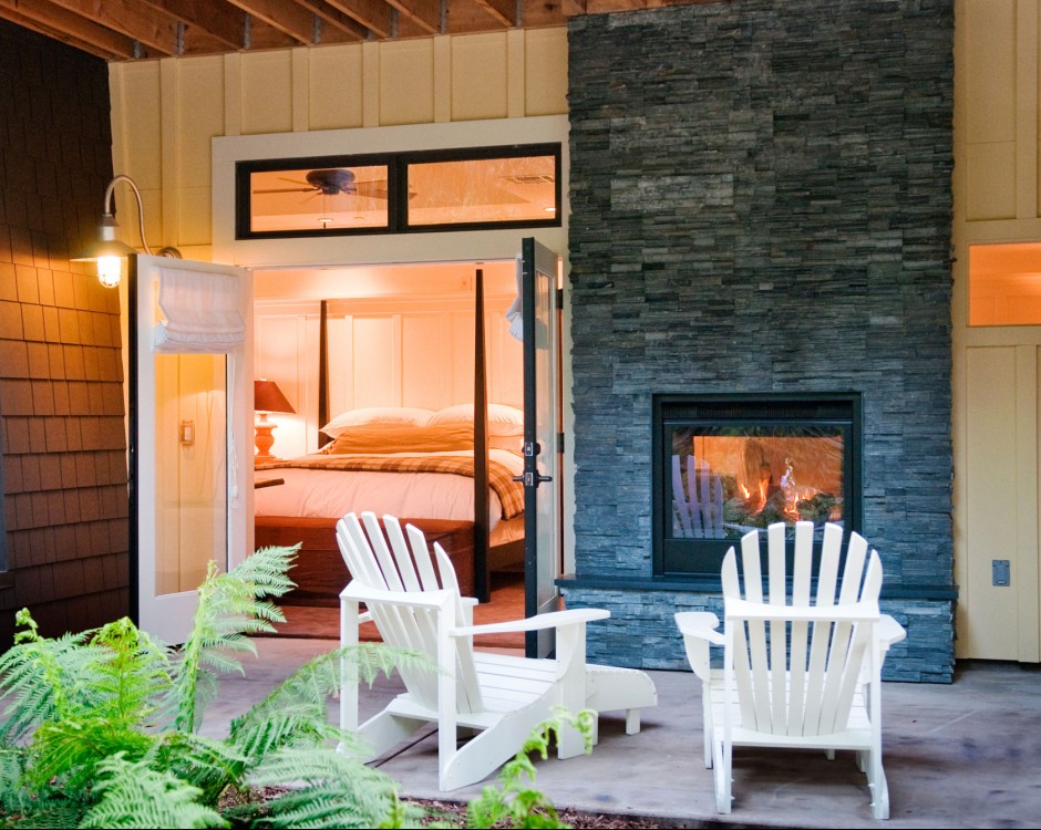 outside porch with white chairs and fireplace with room in background