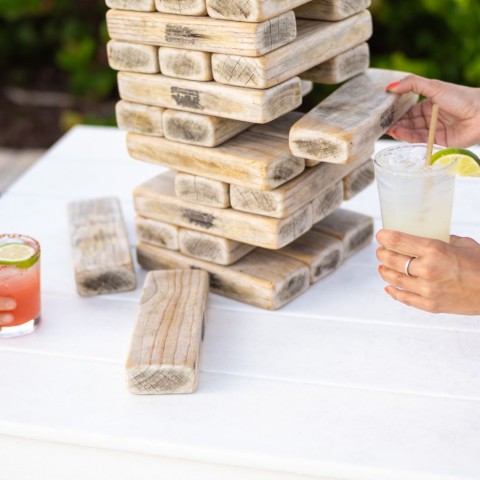 people playing jenga and holding cocktails