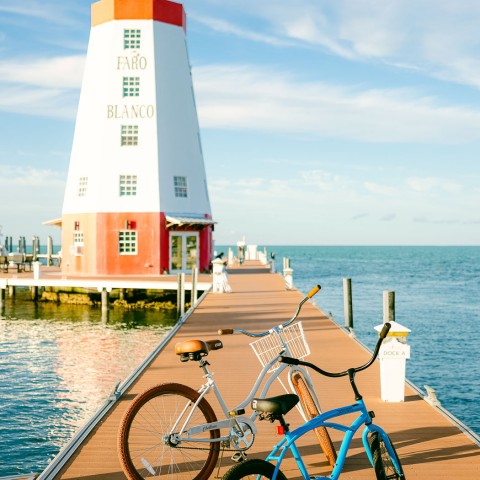 bikes on a dock with lighthouse in the background