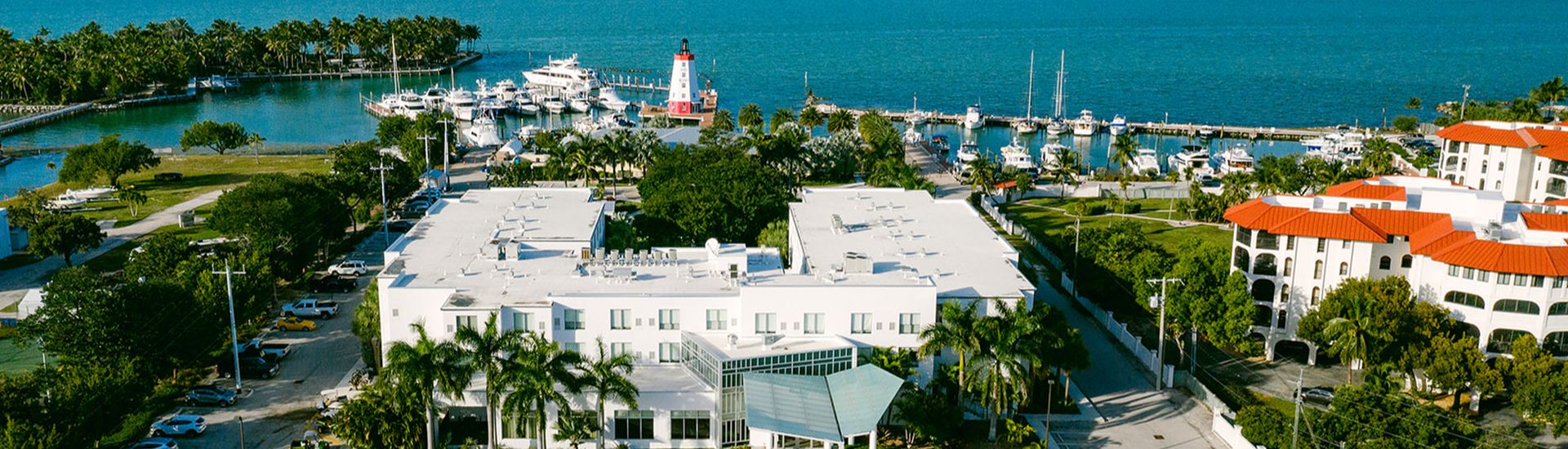 white building with water and lighthouse in the background