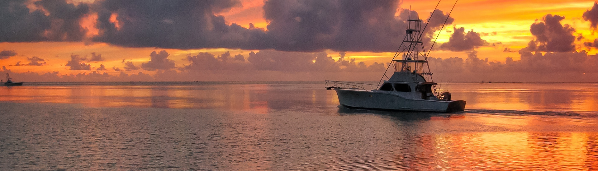 boat anchored on the ocean during sunset