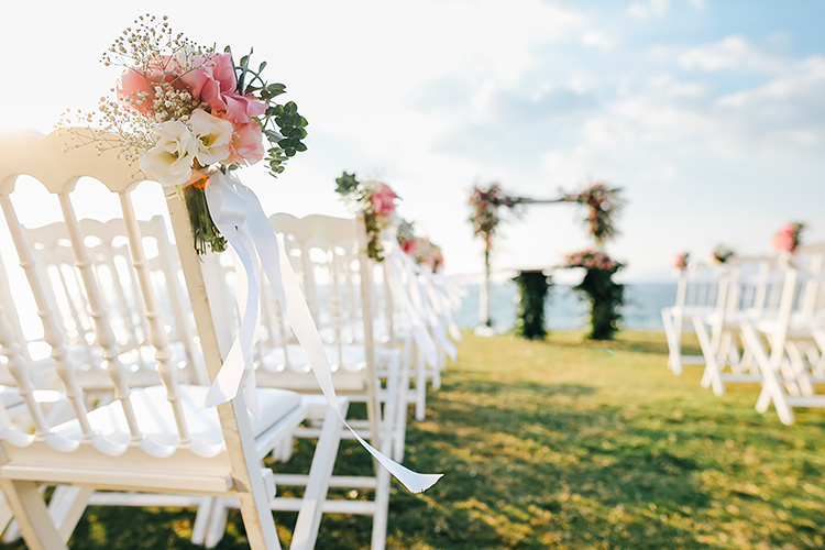 pink and white flowers on a white wedding chair