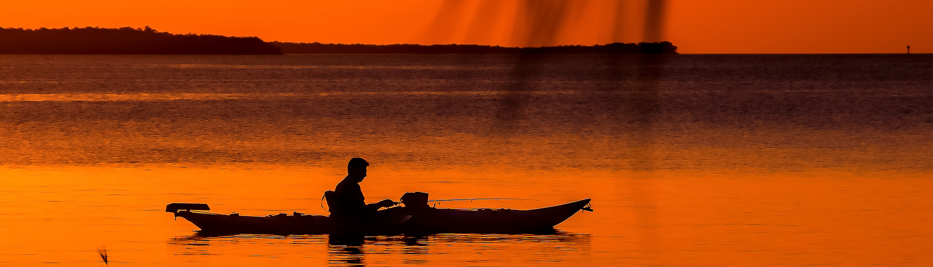 man on a kayak on red sunset