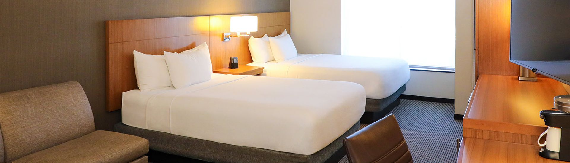 2 queen beds with tan couch