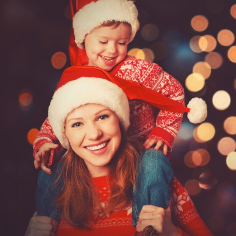 Mom carrying son on shoulders wearing winter clothing