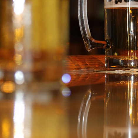 Mug of Amber beer with blurry beer in foreground