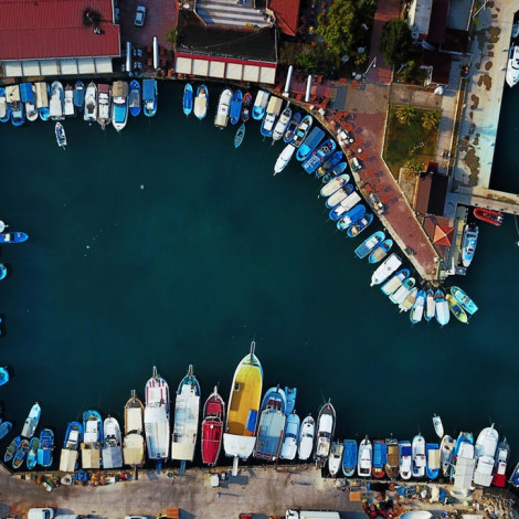 aerial view of many boats docked in harbor on green blue water