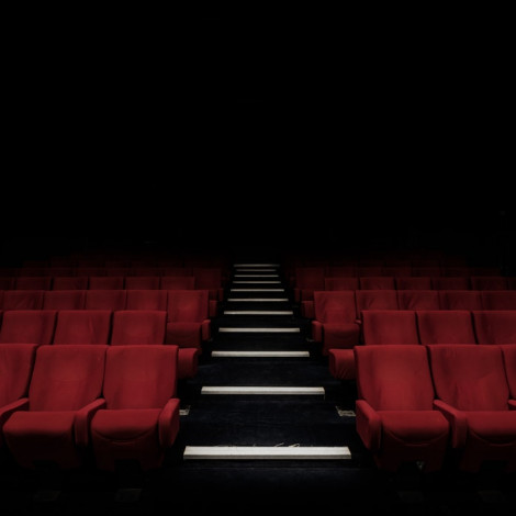 empty red chairs in a playhouse with a black staircase