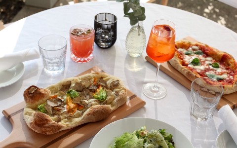 a table with an assortment of pizzas and drinks