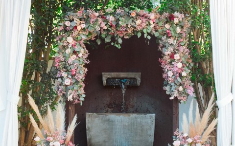 a floral garland over an outdoor fountain