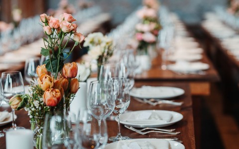 a wooden table setting with floral centerpieces