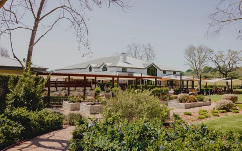 winery seating in front of white building with sun shades hanging