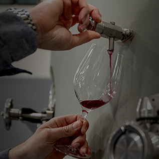 gallery pouring red wine from a tap