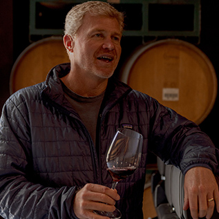 gallery a man holding a glass of red wine