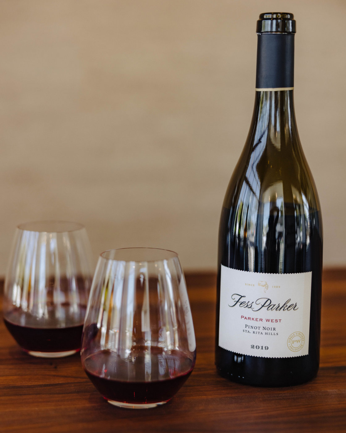Bottle of 2019 Parker West Pinot Noir poured into two wine glasses