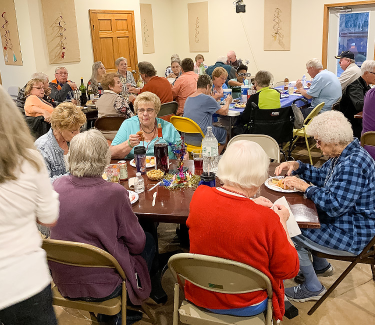 a group of older people eating at tables