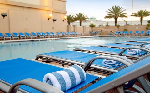 blue pool chairs with towels on top