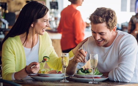 young couple eating salads at the restaurant