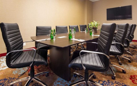 conference room with black chairs and water bottles on table
