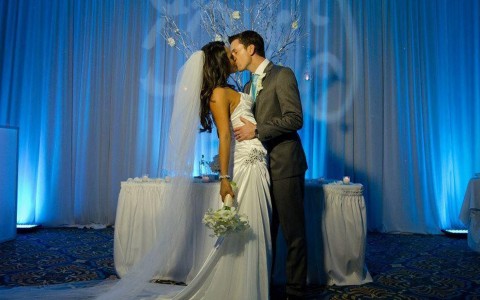 bride and groom kissing in front of their venue