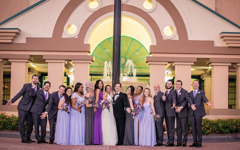 bride and groom with guests taking photos in front of the hotel