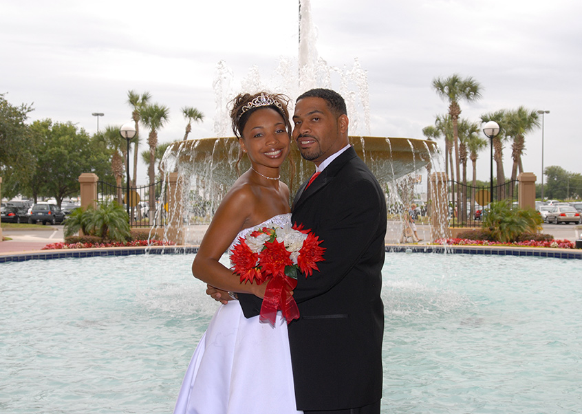 black married couple taking a photo in front of fountain