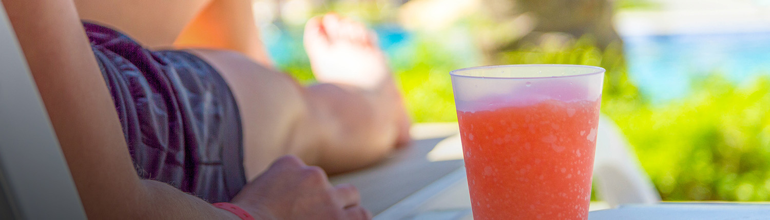person relaxing with a red frozen drink on the side