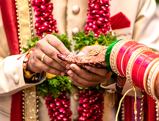 indian bride and groom putting on rings