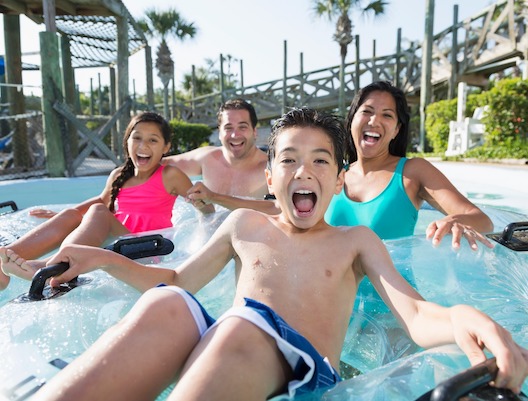 family on floats on a lazy river pool