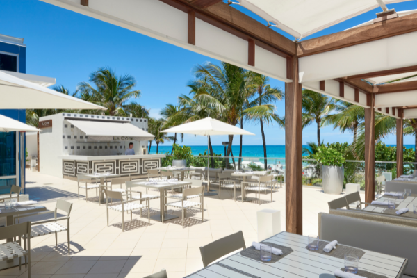 la cote outdoor dining with sunny weather and palm trees 