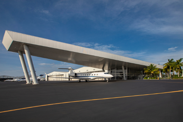 Opa Lock Executive Airport with a plane under the hanger and blue skies 