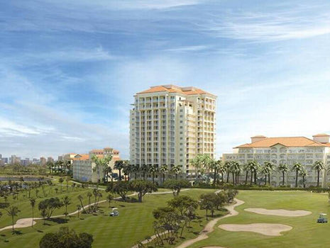 General view of one of a big white hotel next to a golf field on a daylight 