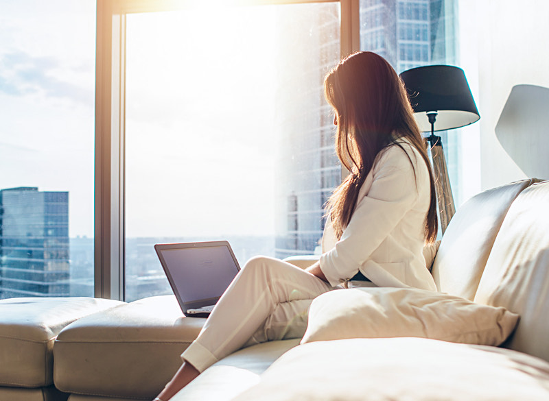 woman sitting on the couch with her laptop