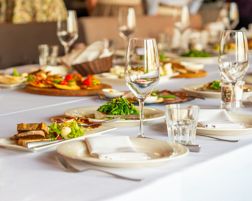 table full of elegant dishes served with glasses of wine
