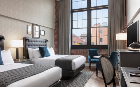 foundry double queen room with upholstered headboards and large windows