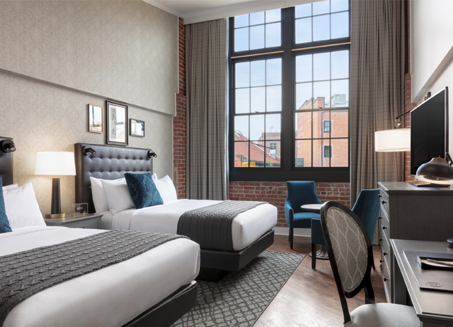 foundry double queen room with upholstered headboards and large windows