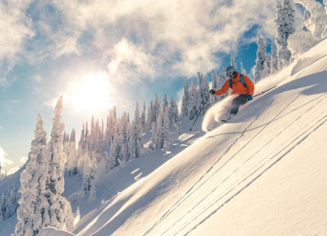 skiing down a slope at sunset
