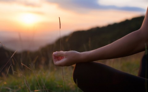 woman meditating on a yoga mat outdoors