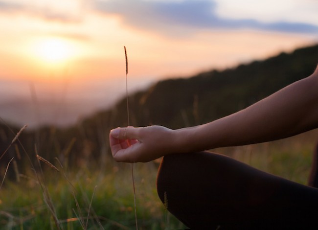 woman meditating on a yoga mat outdoors