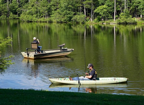 two males fishing on a lake 