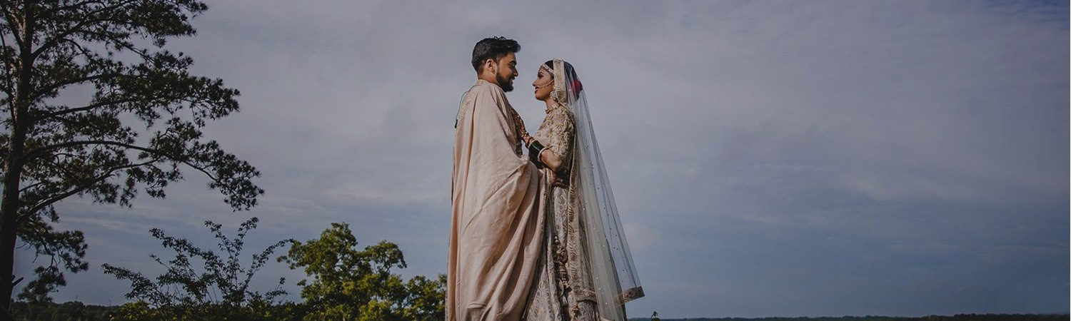 Couple in ethnic wedding attire holding each other