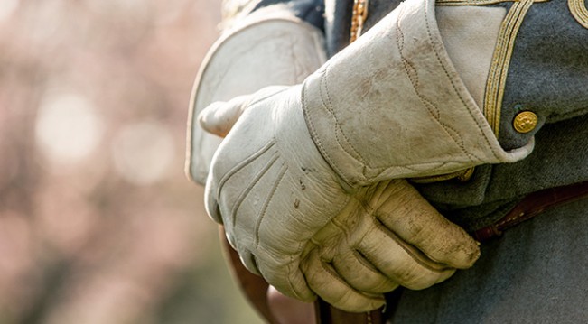 Close up of civil war military man's crossed hands wearing gloves