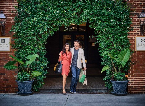 Couple walking out of the French Quarter Inn with shopping bags  